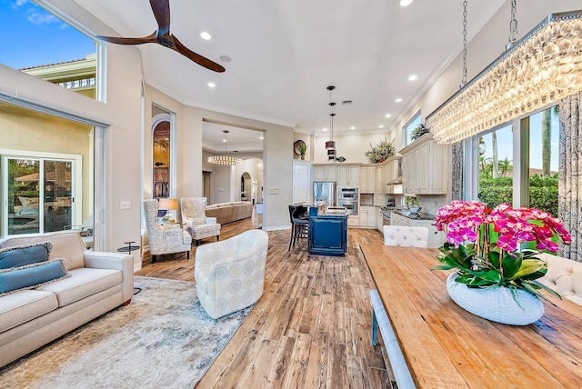 dining area with light hardwood / wood-style floors, ceiling fan, and crown molding