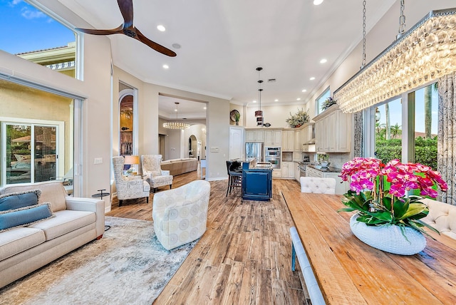 7190 Tradition Cove Ln E, West Palm Beach, FL 33412 - living room featuring recessed lighting, crown molding, plenty of natural light, a ceiling fan, and light wood-type flooring