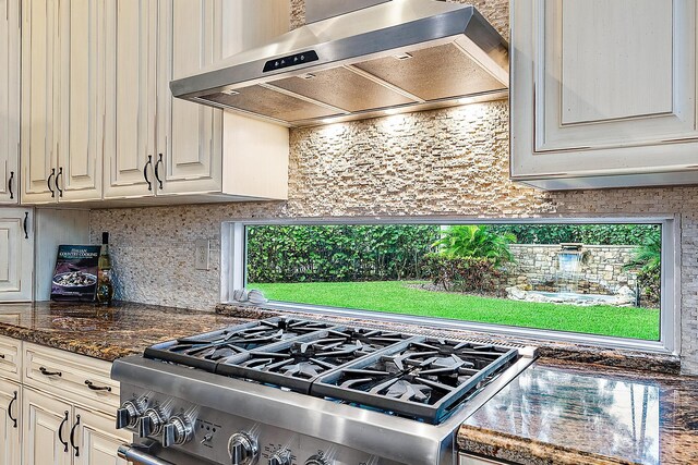 7190 Tradition Cove Ln E, West Palm Beach, FL 33412 - kitchen with ventilation hood, stainless steel gas range, and backsplash