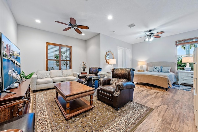 bedroom featuring ceiling fan, wood-type flooring, and a textured ceiling