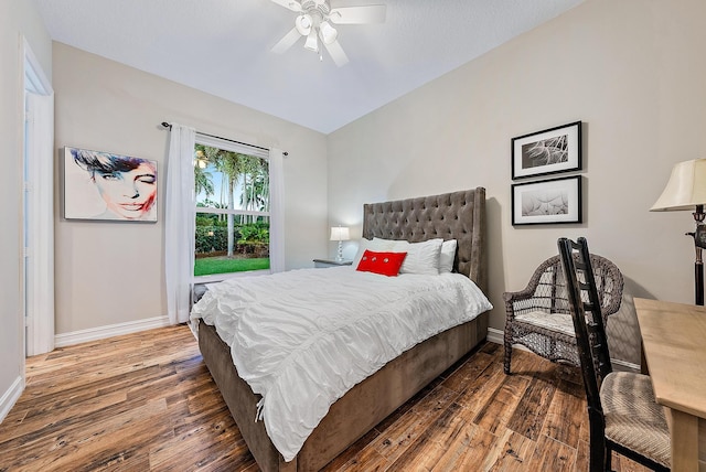 bedroom featuring ceiling fan, dark hardwood / wood-style flooring, and lofted ceiling