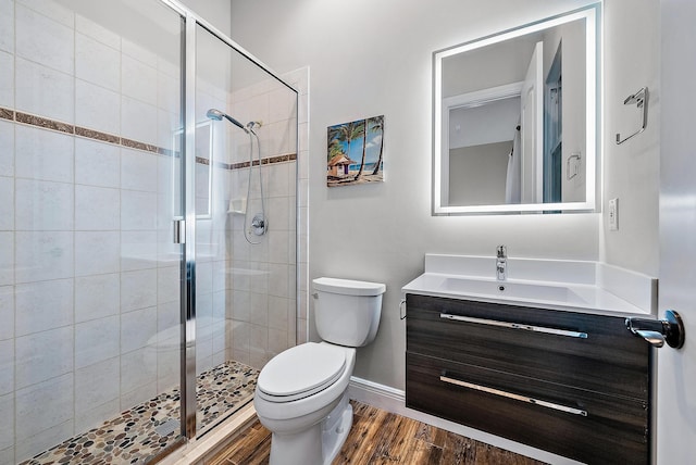 7190 Tradition Cove Ln E, West Palm Beach, FL 33412 - full bathroom with toilet, vanity, a shower stall, wood finished floors, and baseboards
