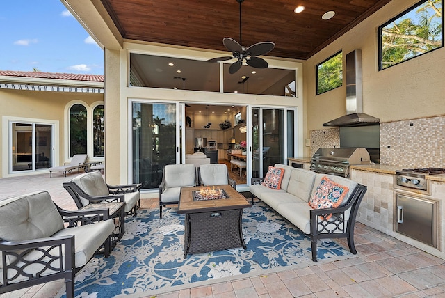 view of patio / terrace with an outdoor kitchen, a grill, ceiling fan, and an outdoor living space with a fire pit