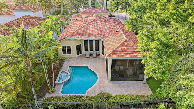 7190 Tradition Cove Ln E, West Palm Beach, FL 33412 - back of house featuring a tile roof, a pool with connected hot tub, a patio, stucco siding, and a fenced backyard
