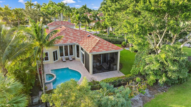 view of swimming pool featuring an in ground hot tub, a yard, a patio, and a sunroom