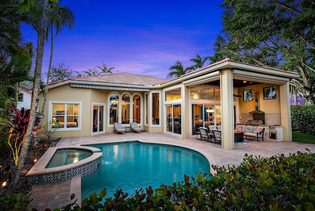 pool at dusk with outdoor lounge area, area for grilling, an in ground hot tub, and a patio