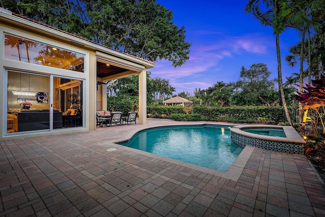 7190 Tradition Cove Ln E, West Palm Beach, FL 33412 - pool at dusk featuring a patio area and a pool with connected hot tub