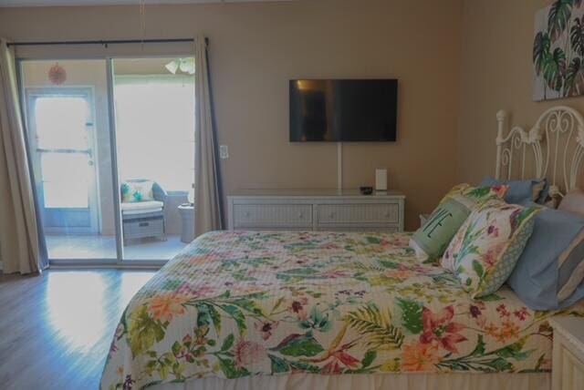 bedroom with wood-type flooring and access to outside