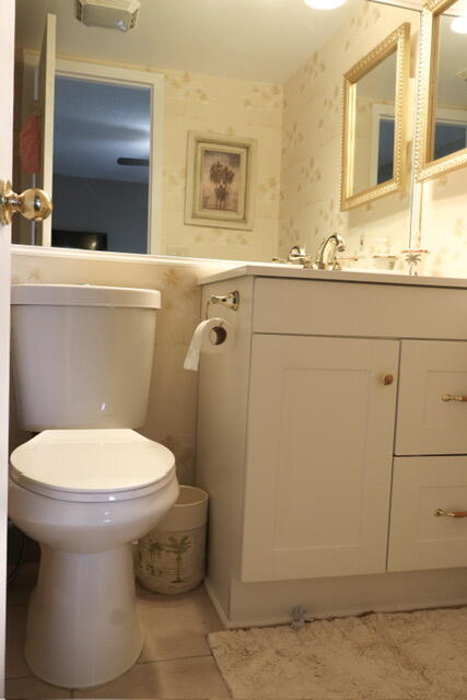 bathroom featuring tile patterned flooring, vanity, and toilet