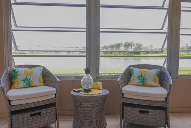 sunroom featuring a water view