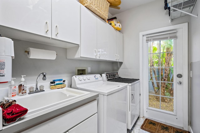 laundry room featuring washer and dryer, an AC wall unit, cabinet space, and a sink