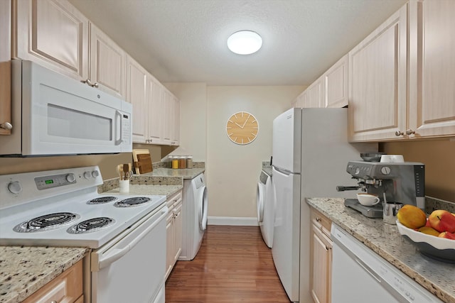 kitchen with white appliances, light hardwood / wood-style flooring, light stone countertops, a textured ceiling, and washer / dryer