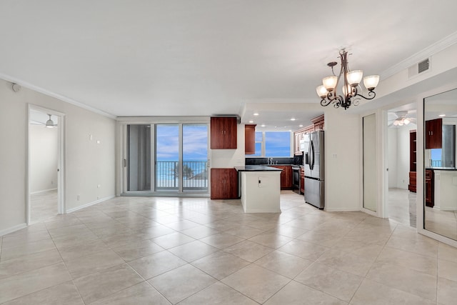 kitchen featuring stainless steel refrigerator with ice dispenser, ornamental molding, ceiling fan with notable chandelier, pendant lighting, and a center island