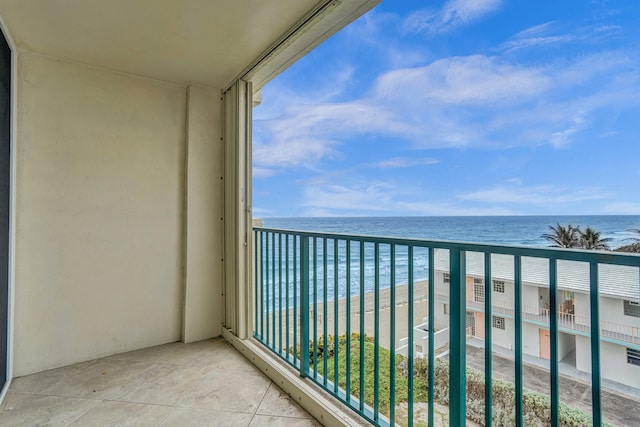 balcony featuring a view of the beach and a water view