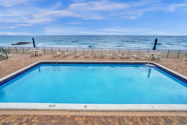 view of pool with a water view and a patio