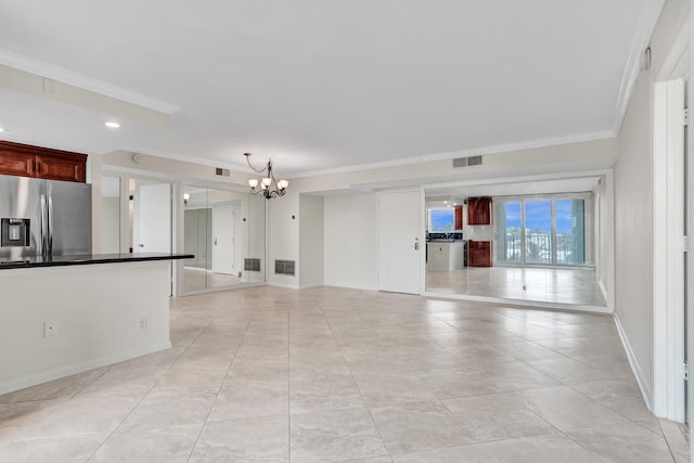 unfurnished living room with a notable chandelier and crown molding