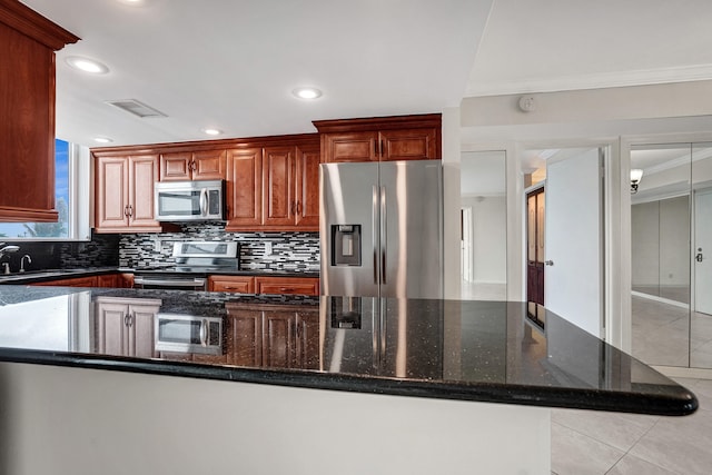 kitchen featuring appliances with stainless steel finishes, sink, ornamental molding, and dark stone countertops