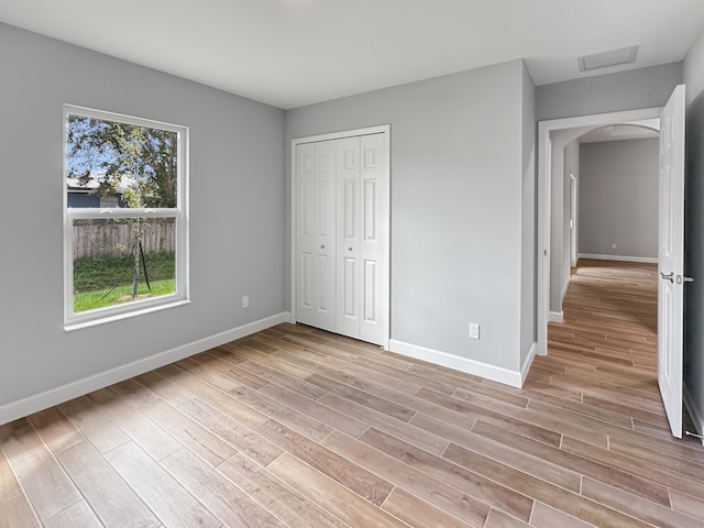 unfurnished bedroom with a closet and light wood-type flooring