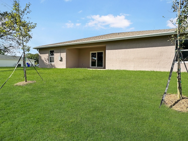 rear view of property with a yard