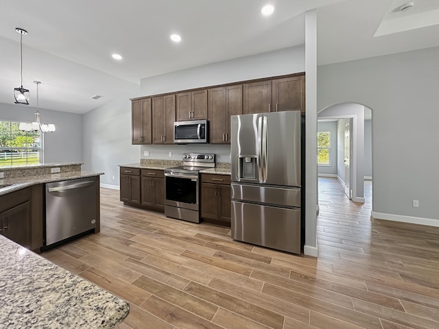 kitchen featuring light stone counters, light wood-type flooring, and appliances with stainless steel finishes