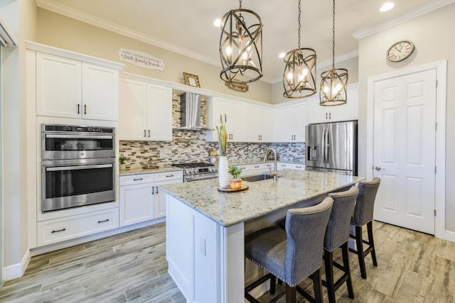 kitchen featuring white cabinetry, appliances with stainless steel finishes, and an island with sink