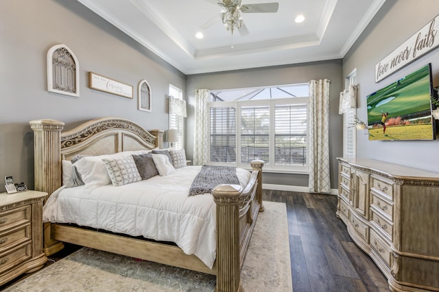 bedroom with dark wood-type flooring, ornamental molding, a raised ceiling, and ceiling fan