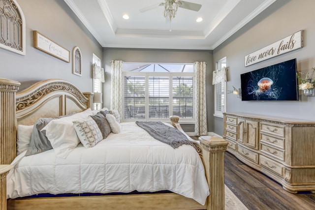 bedroom featuring dark hardwood / wood-style flooring, a tray ceiling, crown molding, and ceiling fan