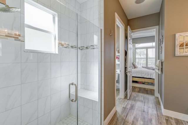 bathroom with wood-type flooring and a shower with shower door