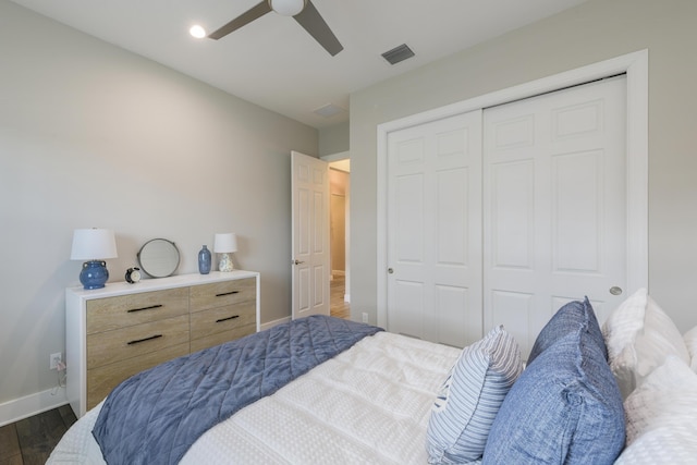 bedroom with dark wood-type flooring, a closet, and ceiling fan