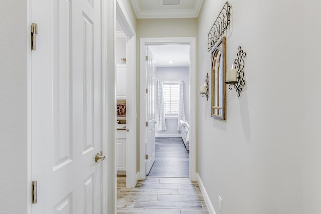 hall featuring ornamental molding and light hardwood / wood-style flooring