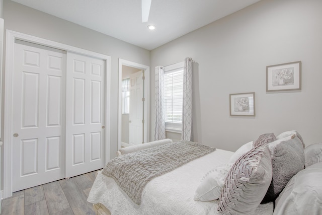 bedroom featuring light hardwood / wood-style flooring, a closet, and ceiling fan