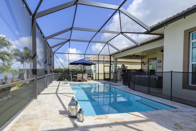 view of pool featuring a lanai, outdoor lounge area, ceiling fan, and a patio area