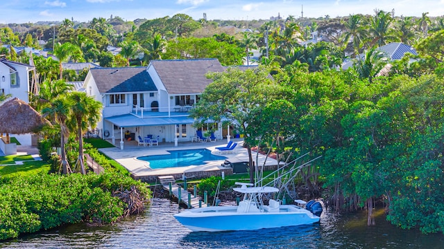 view of swimming pool featuring a patio, a water view, and a dock