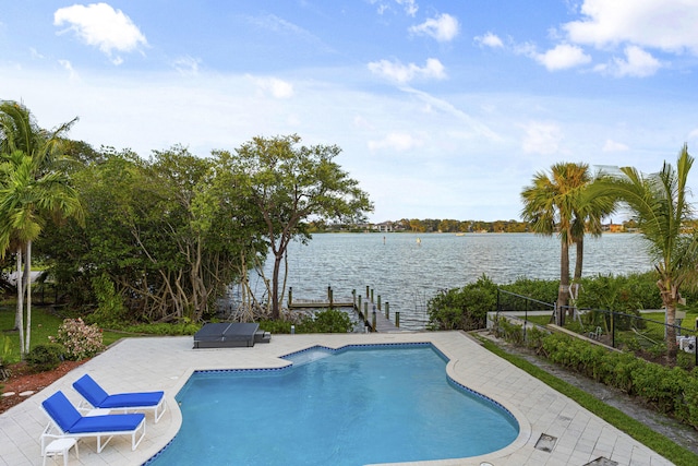 view of swimming pool featuring a patio area, a water view, and grilling area