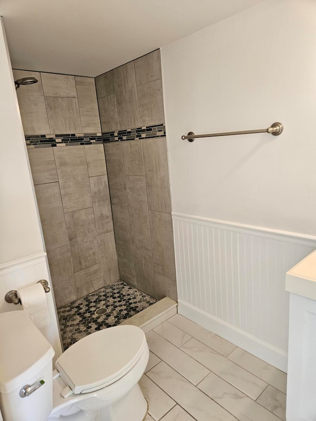 bathroom featuring toilet and a tile shower