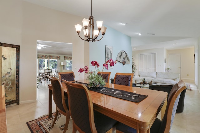 dining space featuring light tile patterned floors, ceiling fan with notable chandelier, and lofted ceiling