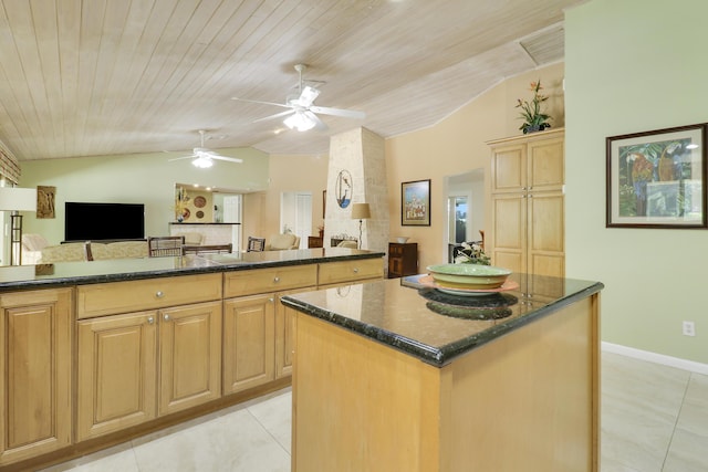 kitchen with light tile patterned floors, a center island, lofted ceiling, and light brown cabinets