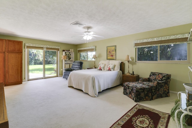 bedroom with a textured ceiling, access to outside, ceiling fan, and light colored carpet