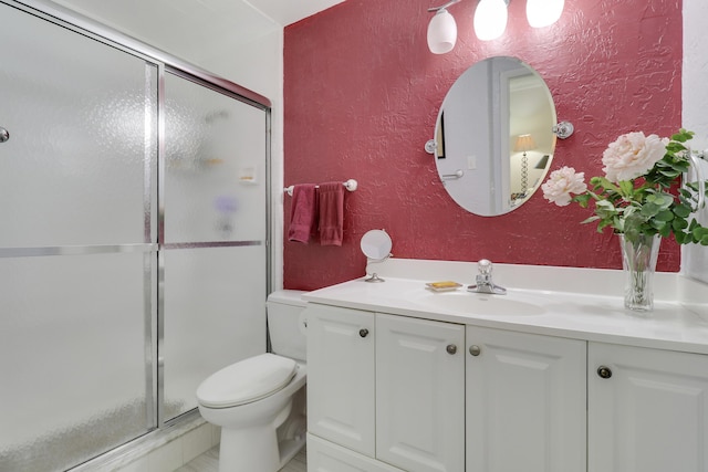 bathroom featuring vanity, toilet, and an enclosed shower