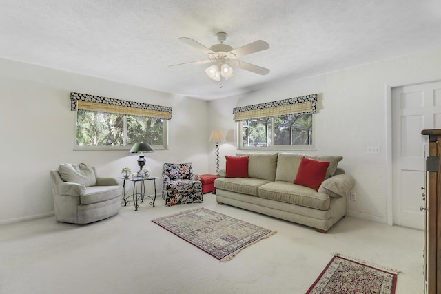 carpeted living room with a textured ceiling, ceiling fan, and a healthy amount of sunlight