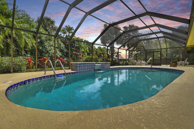 pool at dusk featuring a patio area, pool water feature, and glass enclosure