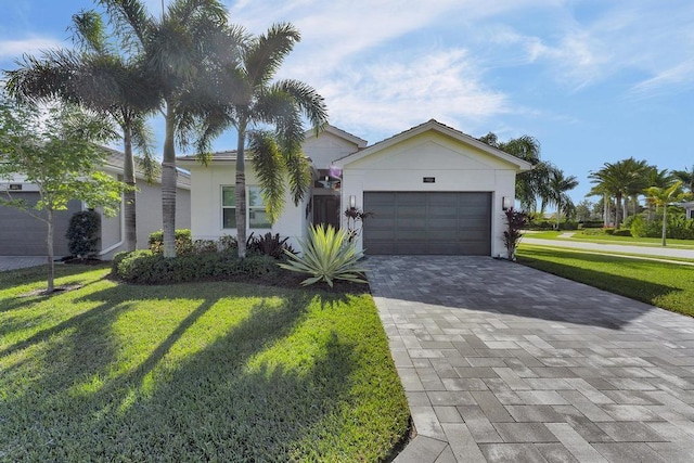 single story home featuring a garage and a front lawn