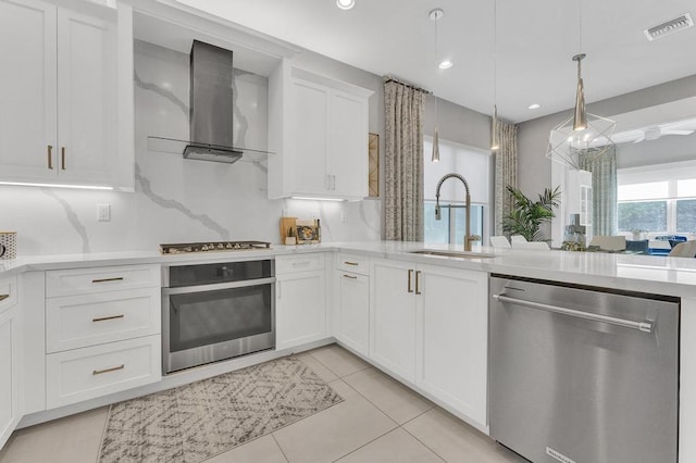 kitchen featuring white cabinetry, sink, wall chimney exhaust hood, stainless steel appliances, and tasteful backsplash