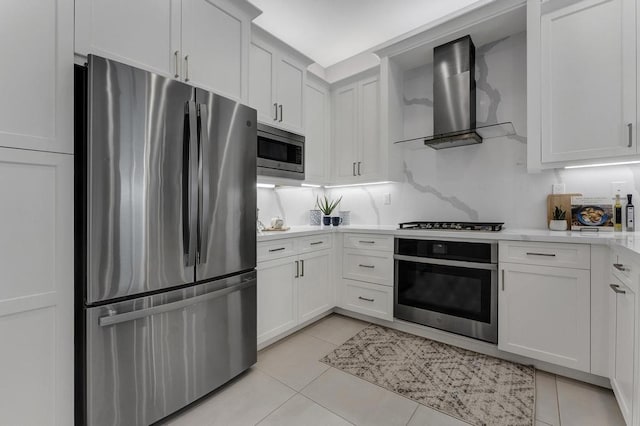 kitchen featuring white cabinetry, wall chimney range hood, stainless steel appliances, and light tile patterned floors