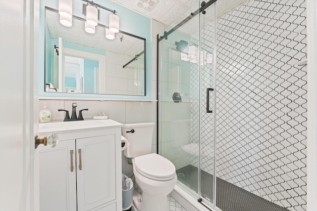 bathroom featuring vanity, an enclosed shower, and toilet