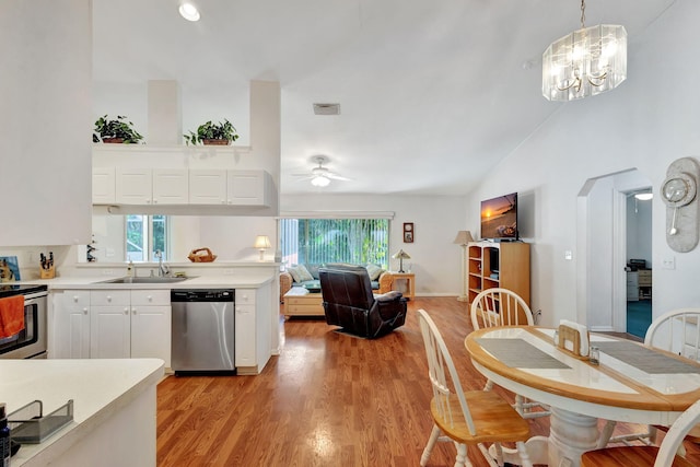 kitchen with decorative light fixtures, ceiling fan with notable chandelier, stainless steel appliances, and plenty of natural light