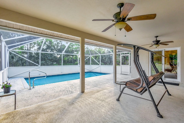 view of pool featuring glass enclosure, ceiling fan, and a patio area