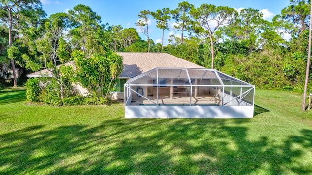 rear view of house featuring a lanai and a yard