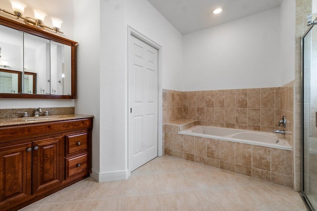 bathroom featuring tile patterned floors, tiled bath, and vanity