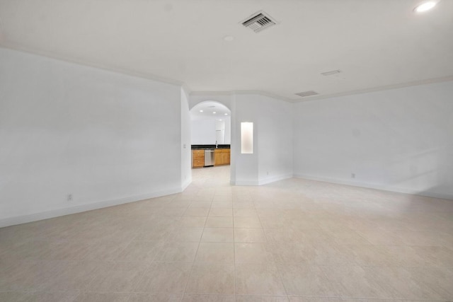 tiled empty room featuring ornamental molding